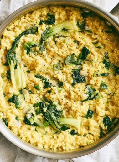 Bowl of anti-inflammatory creamy coconut rice garnished with fresh herbs.