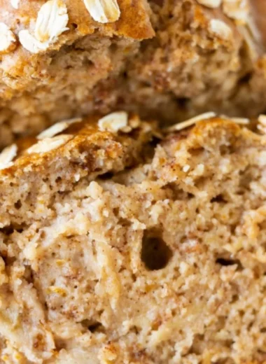 Slice of homemade banana oatmeal bread with oats and ripe bananas