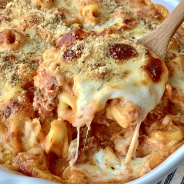Cheesy baked tortellini casserole topped with meat sauce and melted cheese