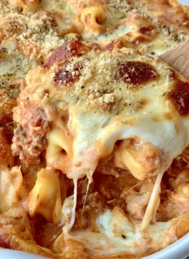 Cheesy baked tortellini casserole topped with meat sauce and melted cheese