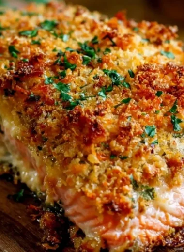 Crispy Parmesan Crusted Baked Salmon topped with herbs and served on a plate
