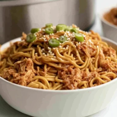 Crockpot Honey Garlic Chicken Noodles served in a bowl with chopsticks