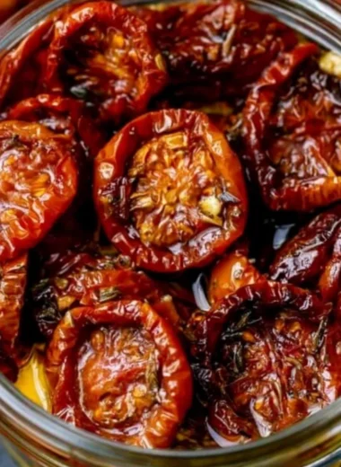 A jar of homemade sun-dried cherry tomatoes with herbs and olive oil