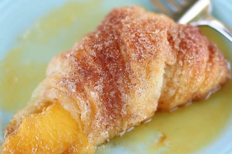 Delicious Peach Cobbler Dumplings served in a bowl with a scoop of vanilla ice cream